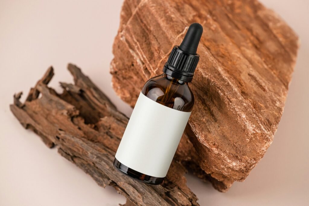 Minimalist image of a brown dropper bottle with a blank label on rustic wood, ideal for natural products.
